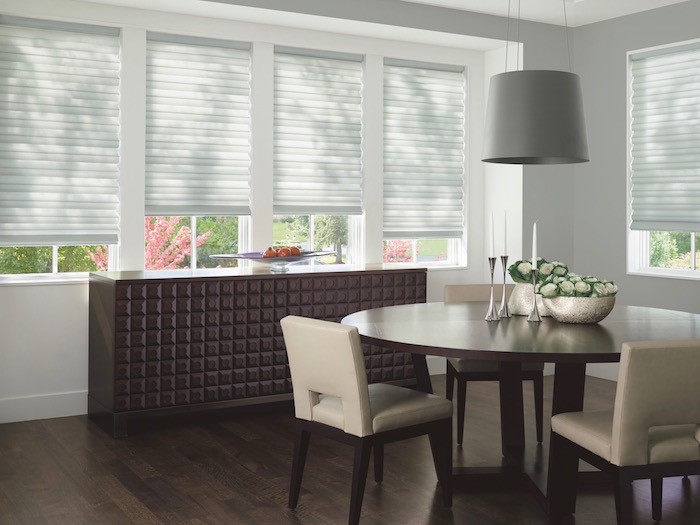 A dining room with a cabinet and decorative glass bowl.